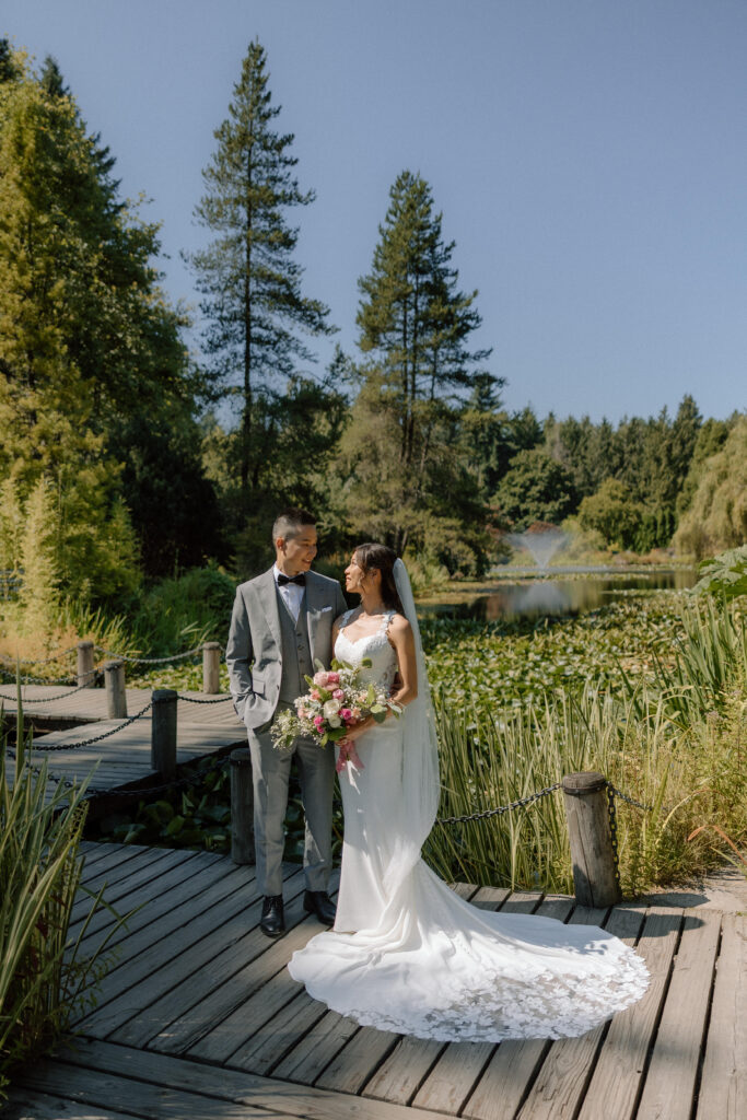 Bride and groom standing on the dock near Heron Lake in the VanDusen Garden a Lower Mainland wedding venue
